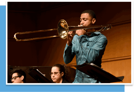 a young black man plays the trombone